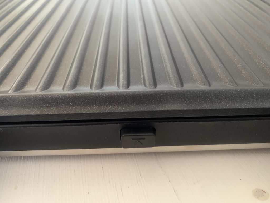 WMF Lono Kontaktgrill von unten mit Kabelaufwicklung Nahaufnahme Entriegelungstaste für Grillplatte