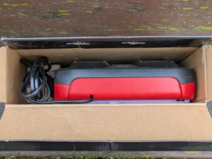 Verpackung des Ladegerätes und des Akkus des Einhell GE-HM 1838 Spindelmähers geöffnet